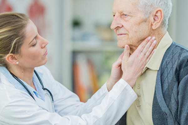 医生检查老人的颈部和淋巴结。