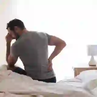 man experiencing back pain in the morning
