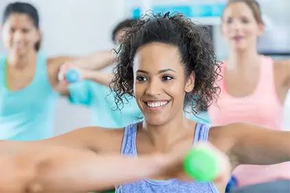 一个微笑的女人在举重集体运动课上。