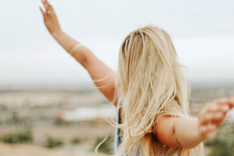 幸福的女人从背后与空气中的武器