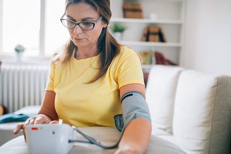 女子测量她在家里的血压。