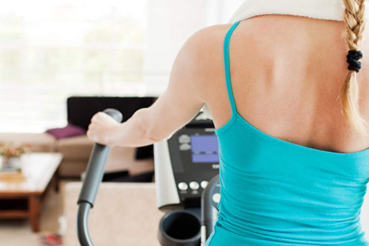 年轻女子在家里的跑步机上行走。