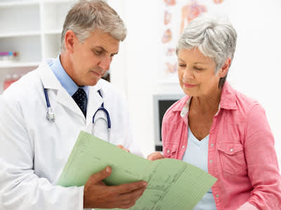老妇审查与她的医生的医疗档案。