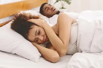 女人不能睡觉，因为她的丈夫正在打鼾