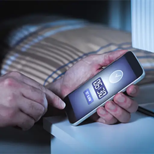 Man setting a smartphone alarm before bed.