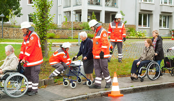 红十字会救援人员帮助老年居民。