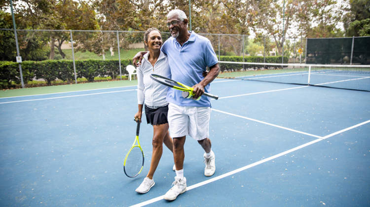 幸福的夫妇在球场上的网球比赛后。