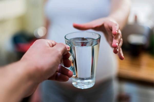 供以人员递妇女一杯水。