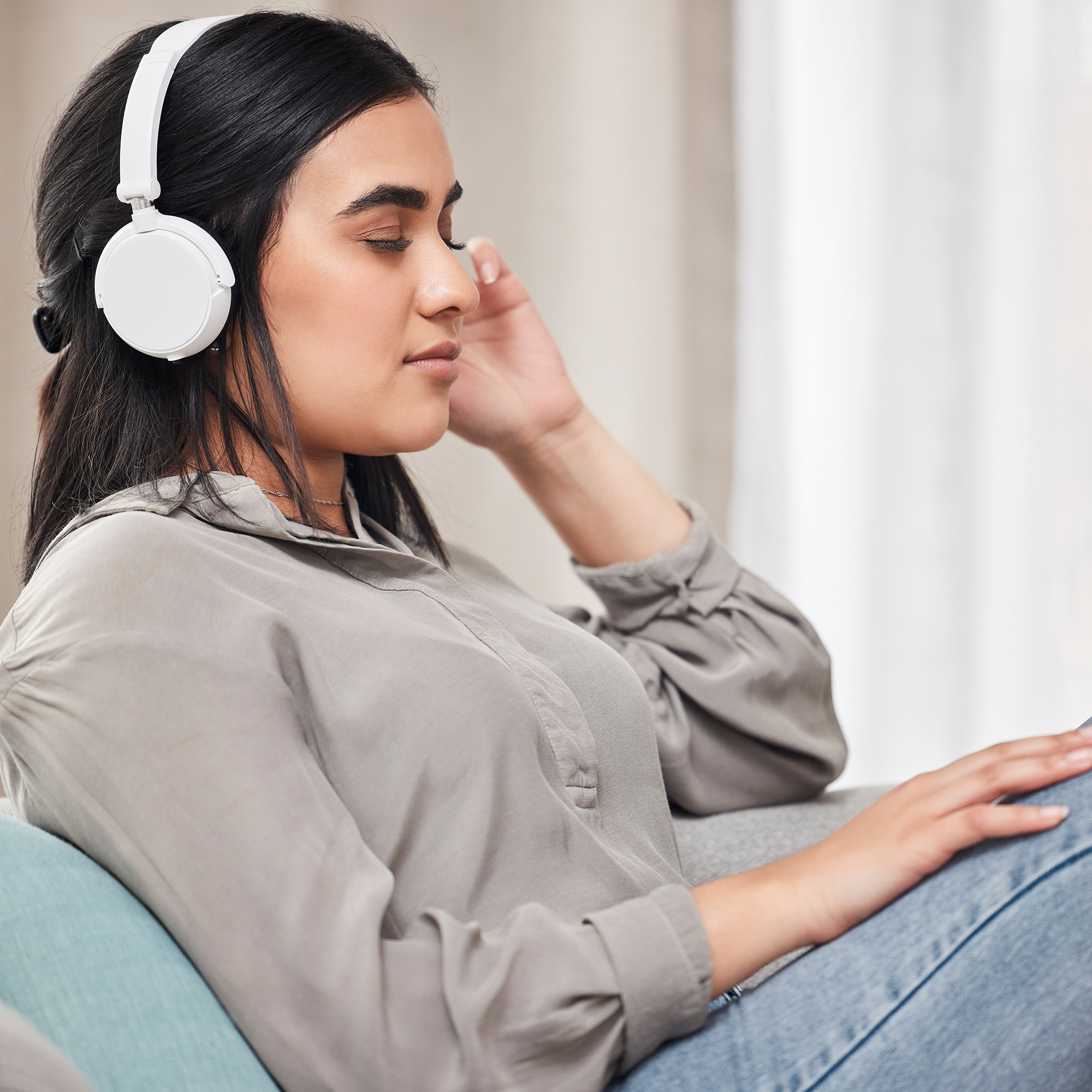 女人在家里戴着耳机听音乐