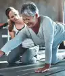 年轻的女人在健身房帮助年长的女人