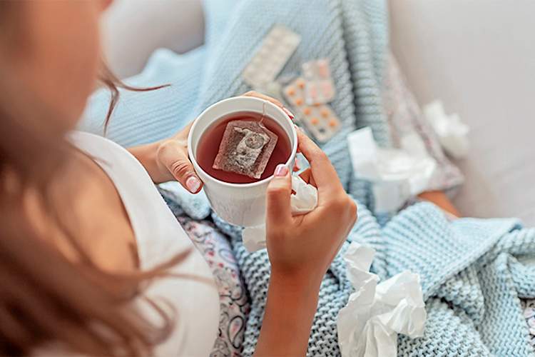 患流感的妇女喝茶。