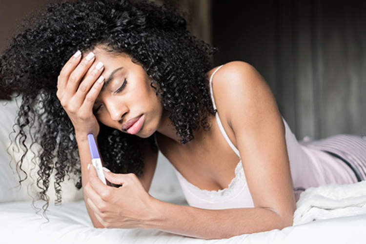 不开心的女人对怀孕测试结果感到失望。