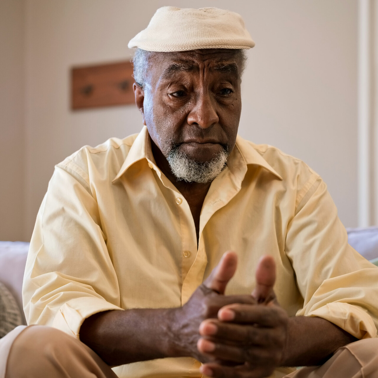 一个悲伤的男人坐在沙发上在家里