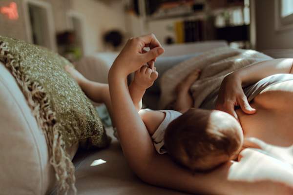 woman laying down breastfeeding