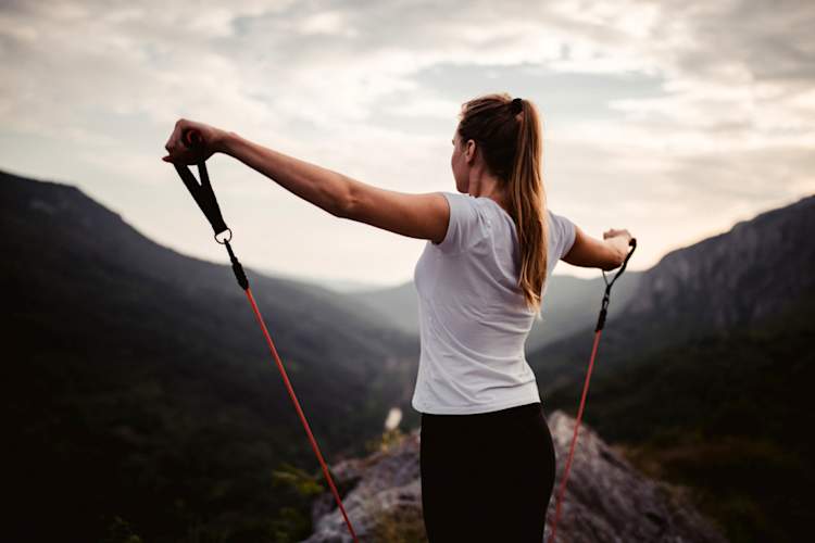 户外使用阻力带的年轻女子