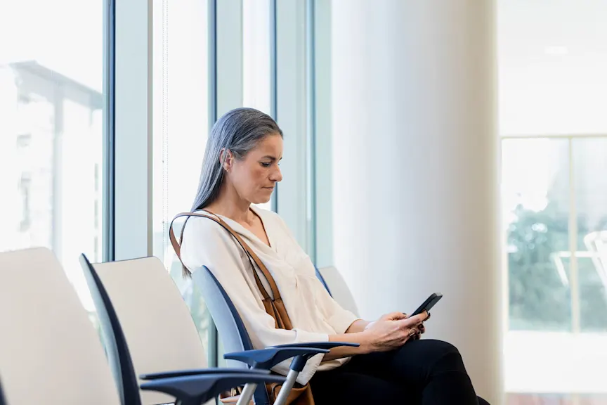 一个女人在医院的候诊室里看着她的手机