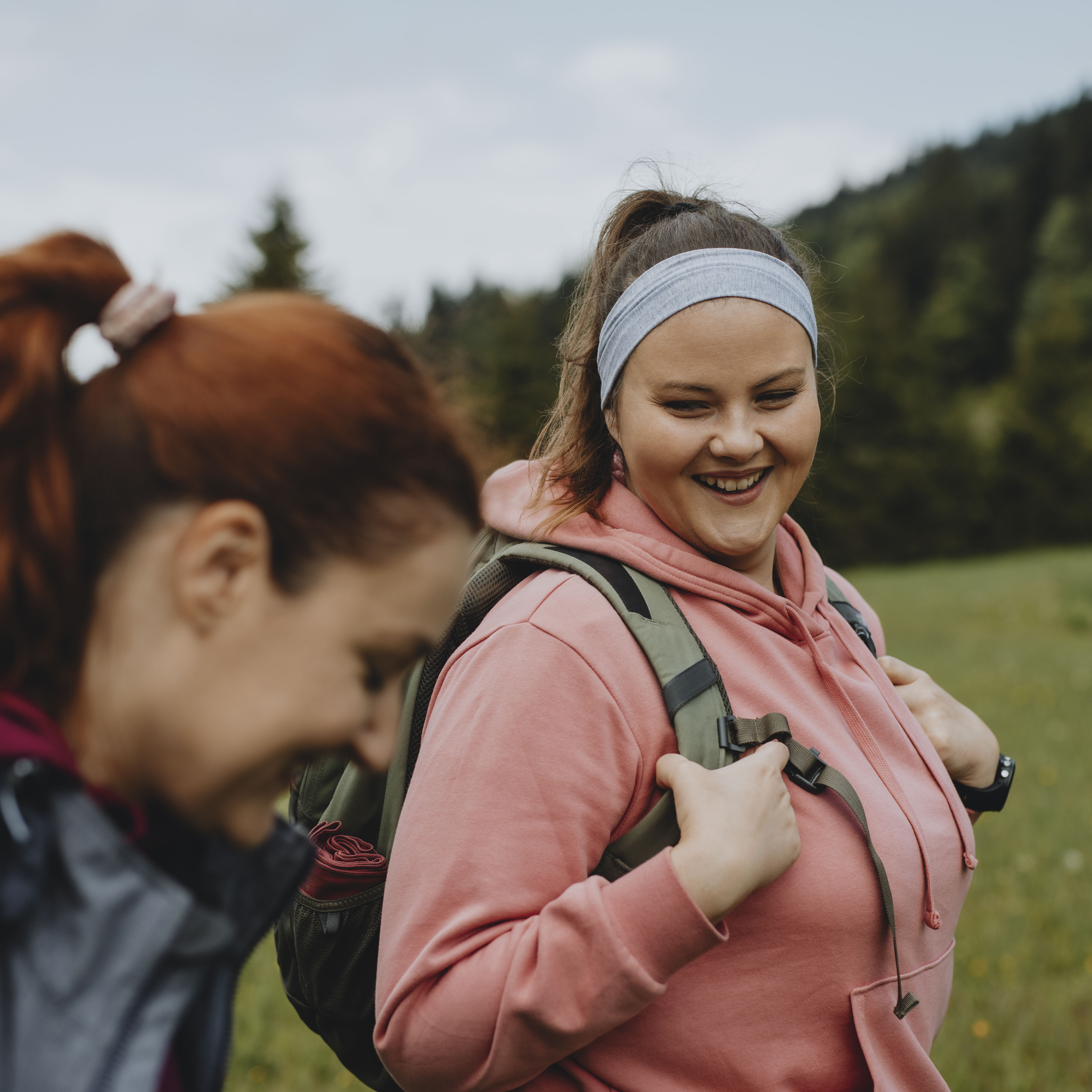 在大自然中度过一天:两个微笑的女人一起徒步旅行。