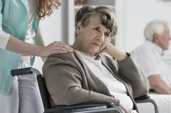 老年痴呆妇女坐在轮椅上，感到无助。