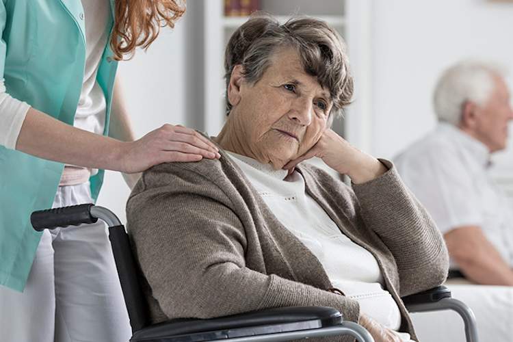 高级女子在轮椅和感觉无助痴呆。