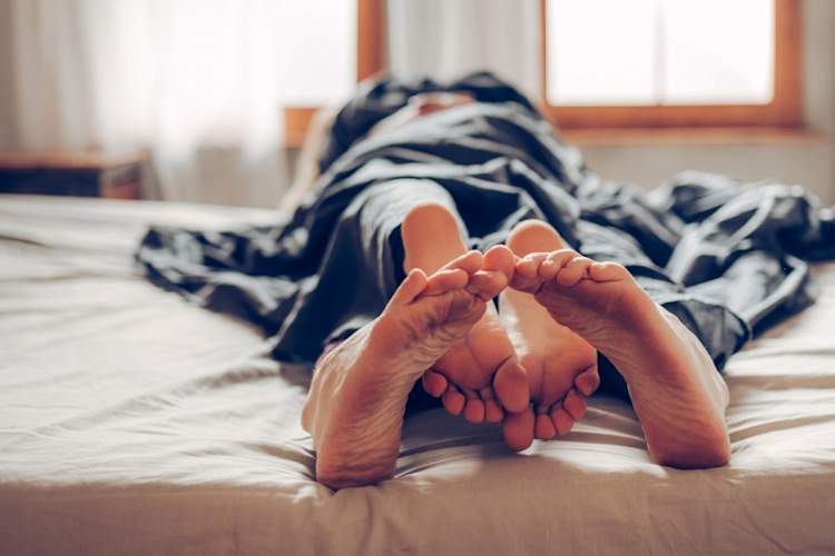双脚盘绕在床上