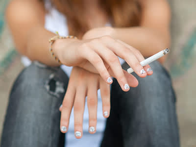 十几岁的女孩拿着香烟。