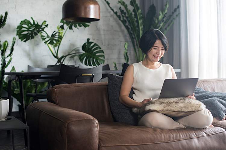 女人在使用笔记本电脑沙发。