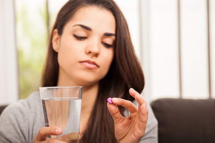 正在吃药的年轻女子。