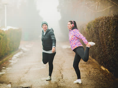 在寒冷的天气跑步前做伸展运动和热身运动。