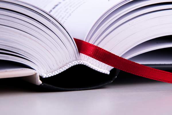 Open booked with bookmark ribbon.