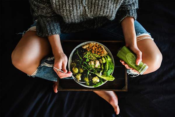 女人在床上吃素食和喝冰沙