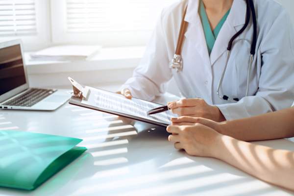 医生和病人都在办公桌讨论在临床上的东西,只是手