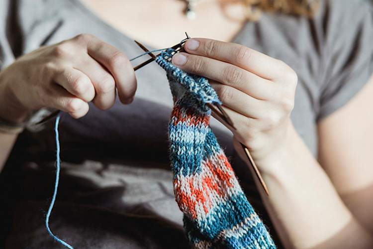 女子试图完成一个项目的针织。