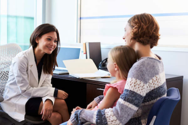 母亲抱着孩子和医生谈话。