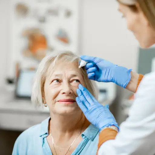 Doctor dripping eye drops on eyes of a senior patient 