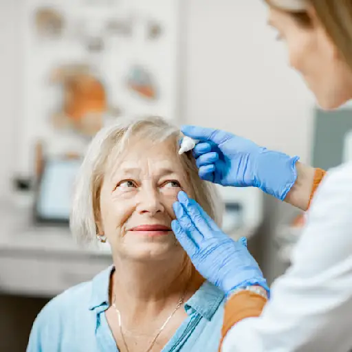 Doctor dripping eye drops on eyes of a senior patient 