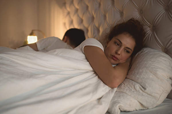 在床上的问题哀伤的妇女。