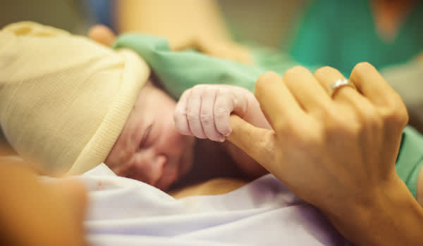 刚出生几分钟的婴儿，由母亲抱着。