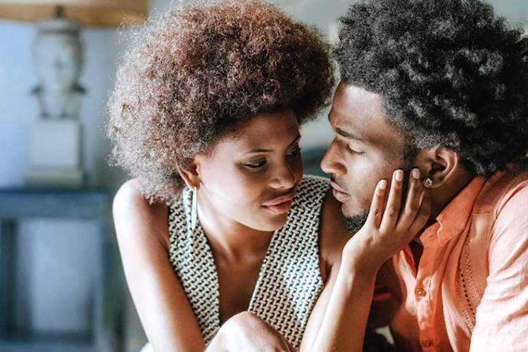 年轻女子温柔而深情地抚摸着她的伴侣的脸。