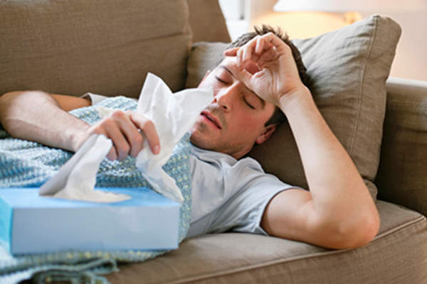 男子在沙发上生病了一个寒冷的寒冷。