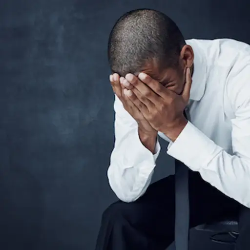 一个双手抱着头的沮丧男人。