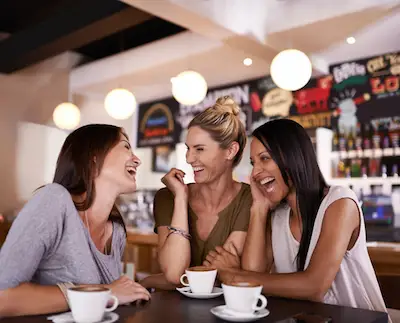 三名女性边喝咖啡边聊天，三分之二经历过胃灼热的人报告说他们的症状影响了他们的睡眠能力。