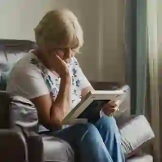Sad woman looking at a photo of a deceased loved one.