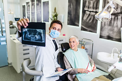 牙医给病人看牙科x光片。