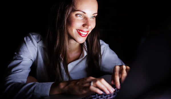 电脑上的女人在晚上。