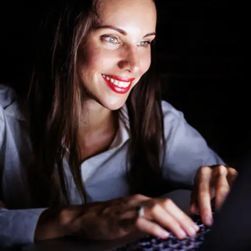 计算机上的女人在晚上。
