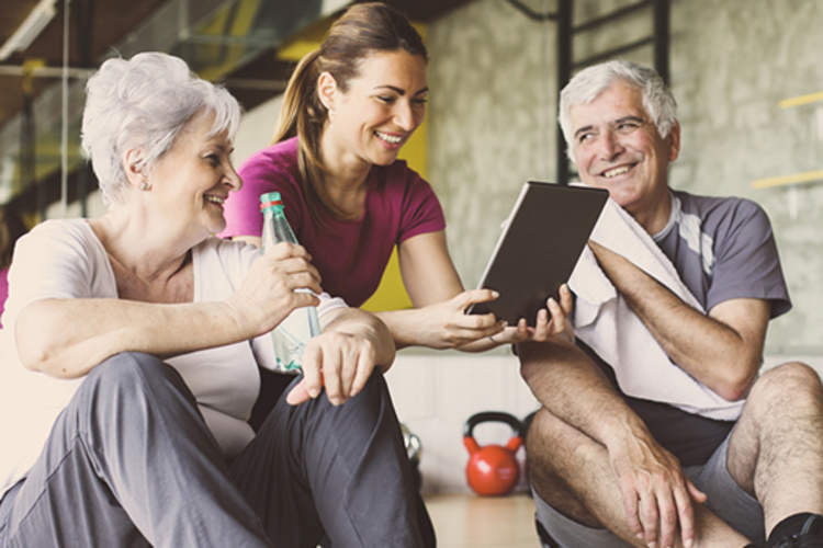 Smiling senior couple with fitness trainer.