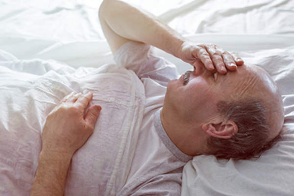 男子与头痛躺在床上。