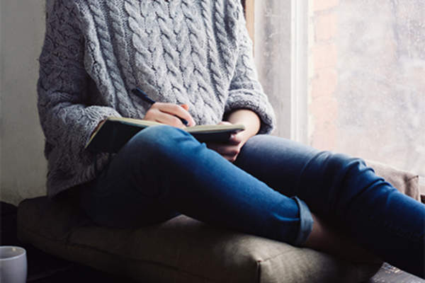 坐在窗边写日记的女人。