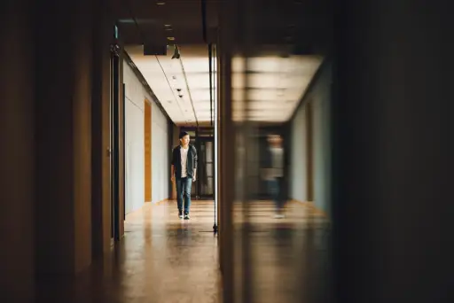 boy walking through school hallway looking at reflection