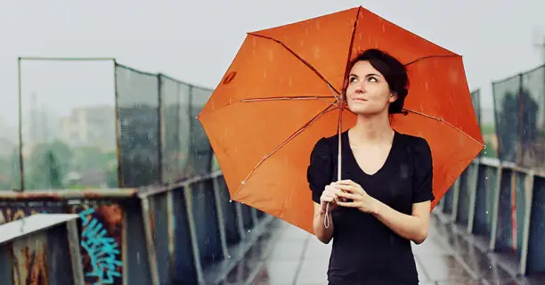 Woman holding an umbrella in the rain.